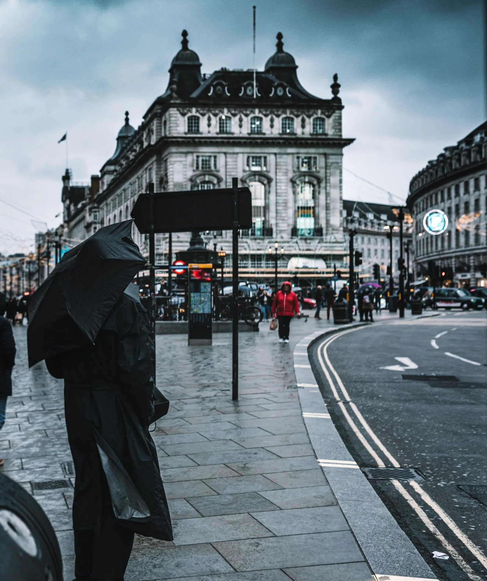 A pedestrian with an umbrella on a rainy London street