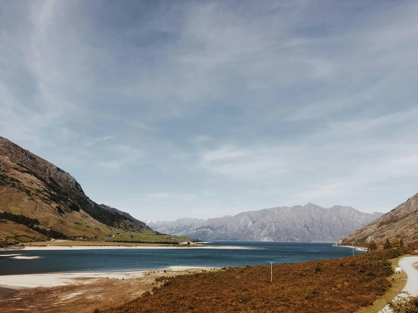 Mountains surrounding Lake Wakatipu under a cloudy sky in New Zealand